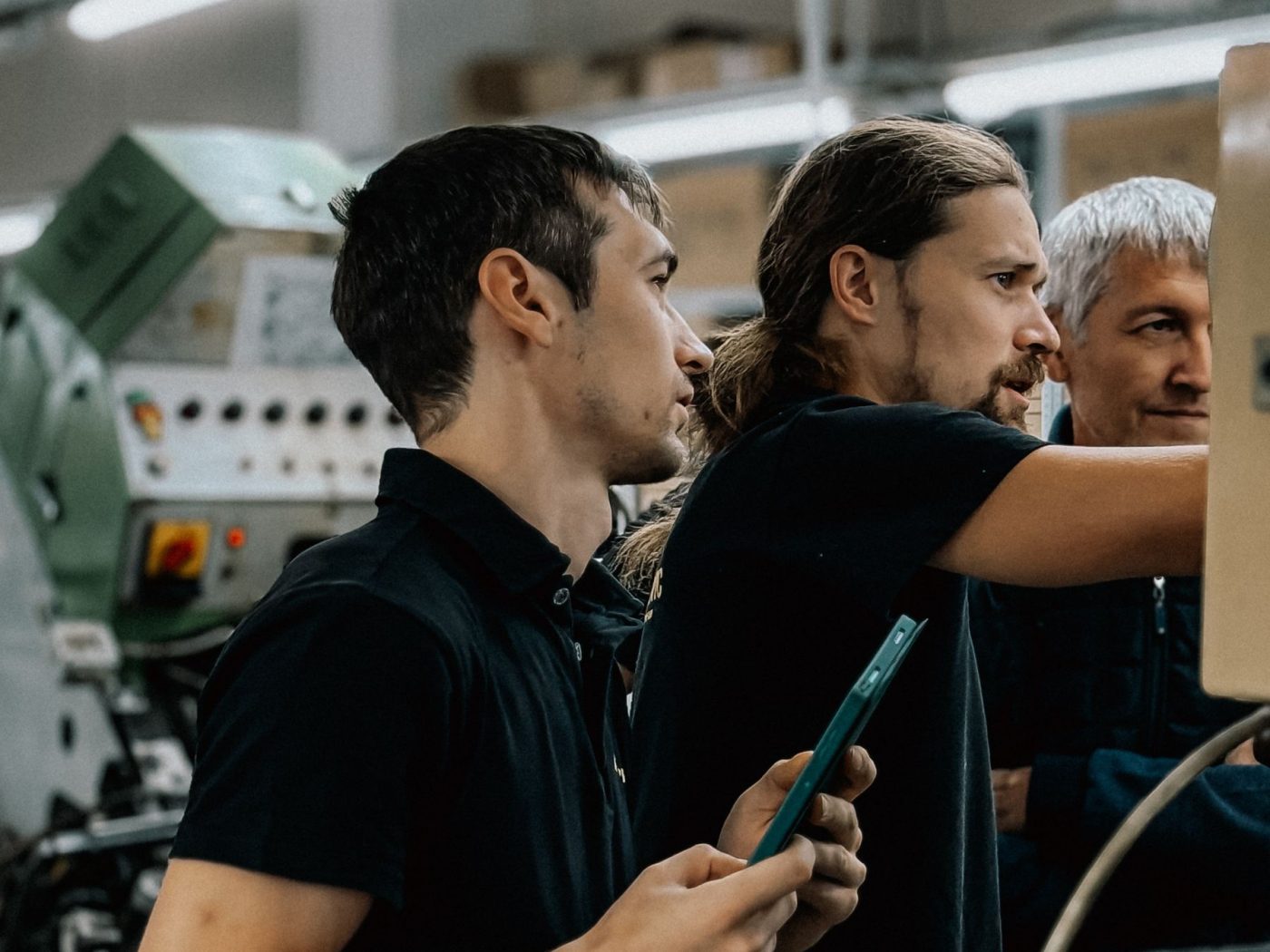 Equipe técnica acompanhando uma máquina no chão de fábrica
